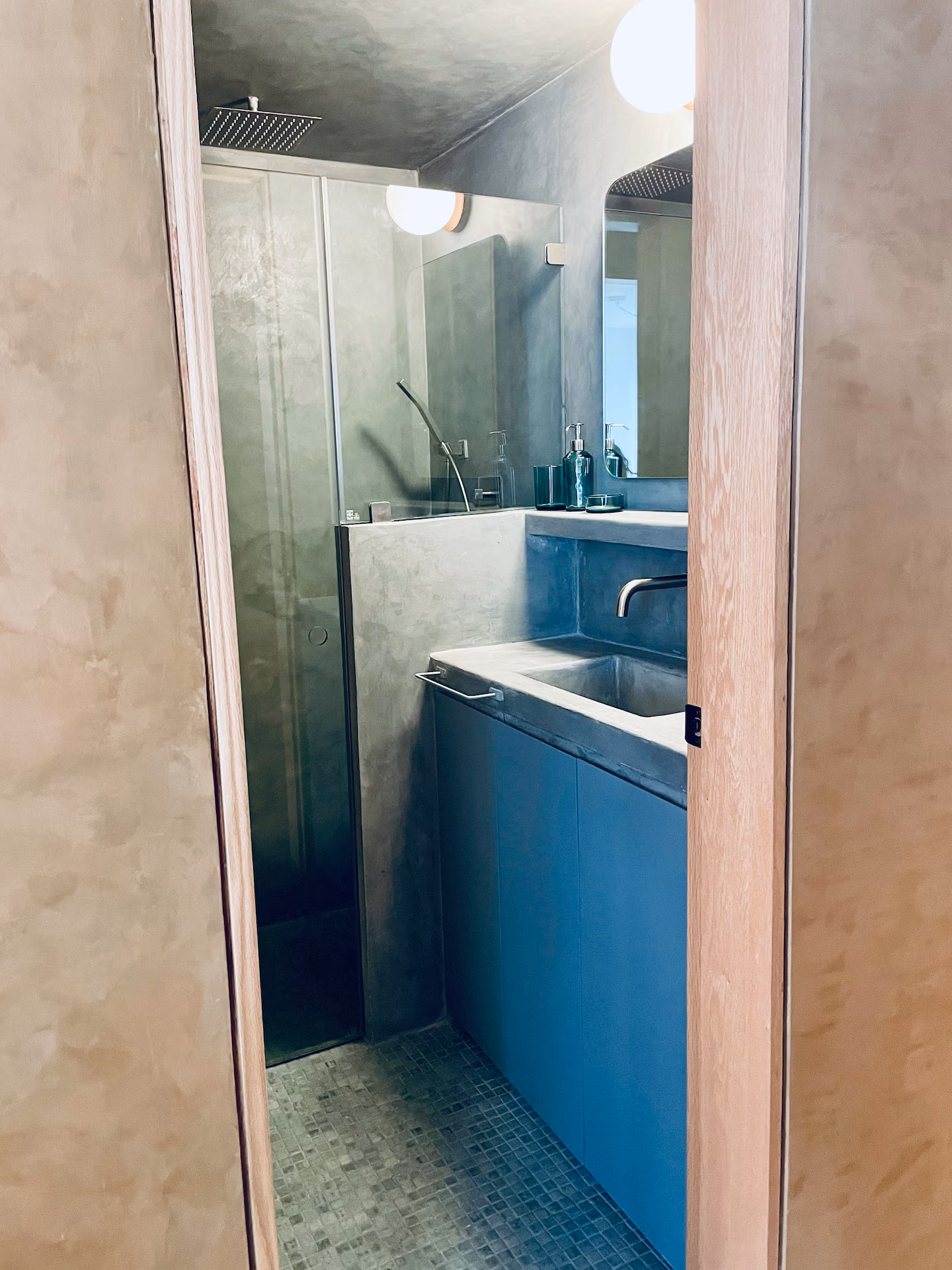 Bathroom shower with concrete and blue tile